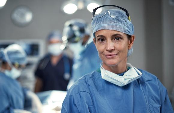 Image of critical care doctor in surgical scrubs smiling