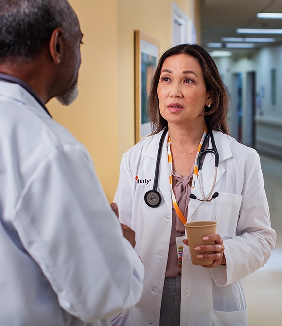 Two Vituity physicians wearing white lab coats smiling