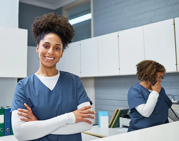 smiling male advanced provider with stethescope and medical gloves crossed arms