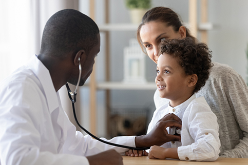 A diverse physician gains the trust of his young patient.
