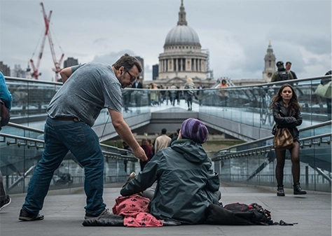 man helping homeless person outside for health in place
