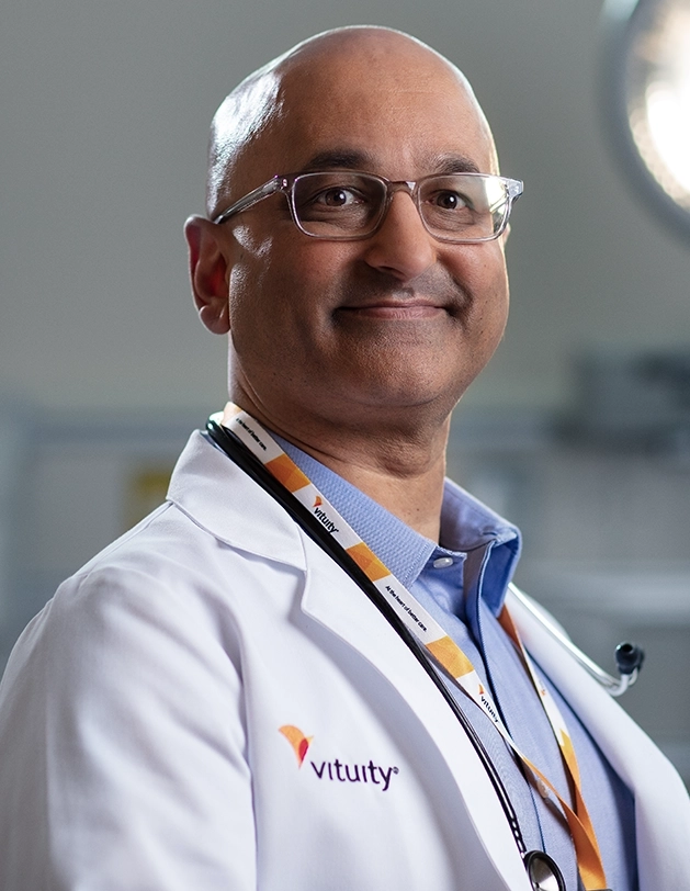 male vituity physician with  white lab coat and stethoscope around neck