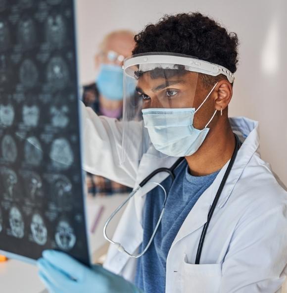 physician analyzing patient scan with mask