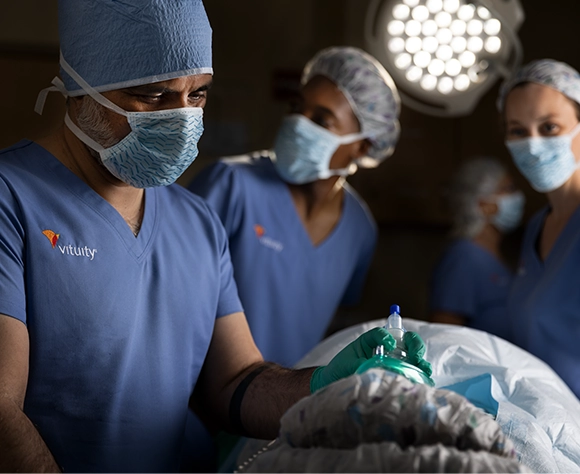 three vituity medical professionals wearing blue scrubs providing healthcare services