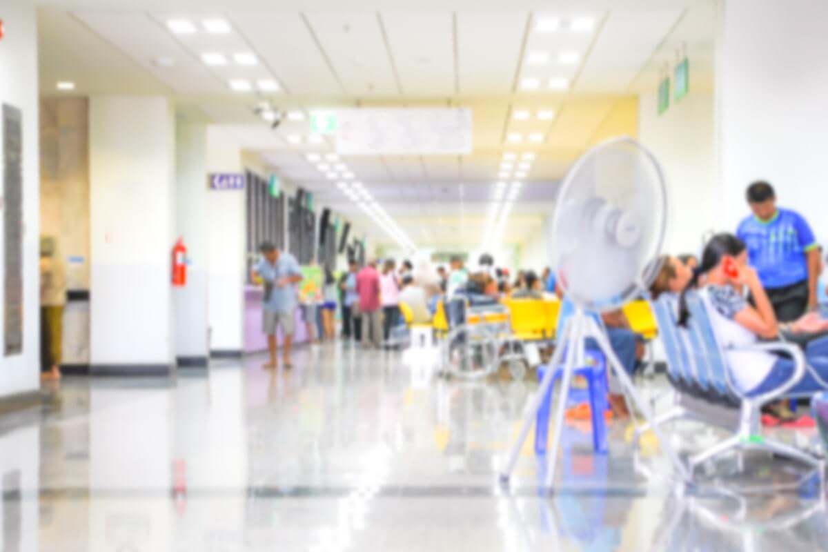 People sitting in a crowded emergency room waiting area