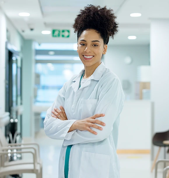 Resident physician standing in a hospital hallway.
