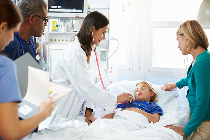 Sick child in emergency department with team of doctors