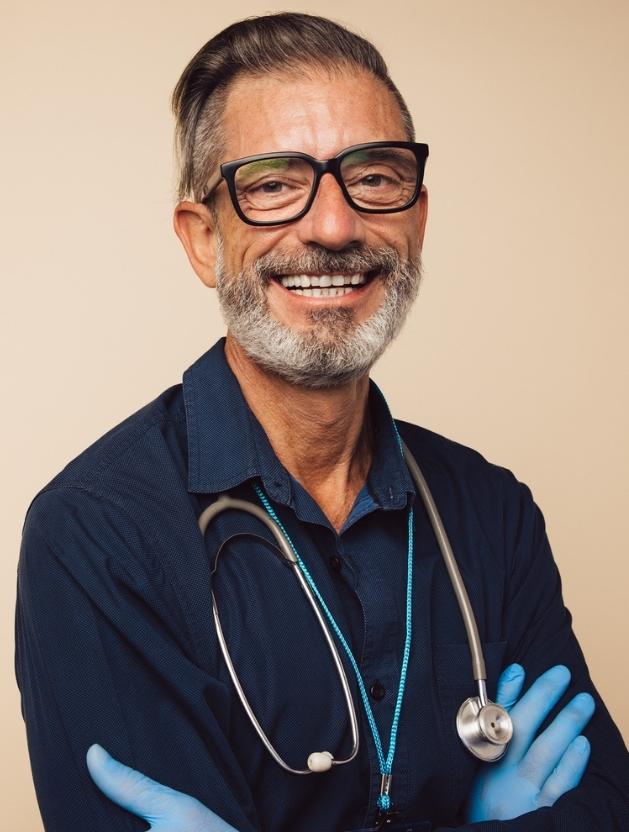 Image of male advanced provider wearing blue shirt with stethoscope around neck
