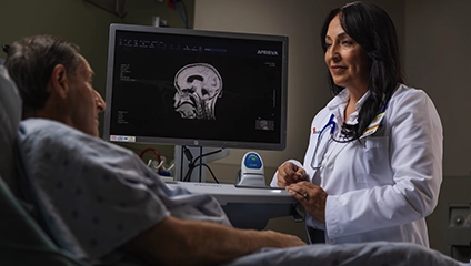 Female Vituity Physician In White Labcoat Consulting Patient Scan Results In Hospital Bed