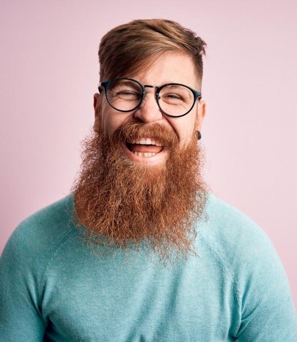 Man smiles with glasses and beard