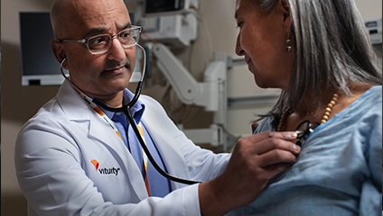 male Vituity doctor in white labcoat checking patient's vitals