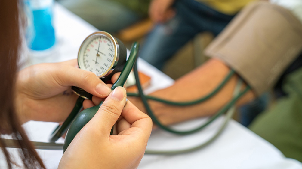 Healthcare worker standing outside and holding a mask and stethoscope 