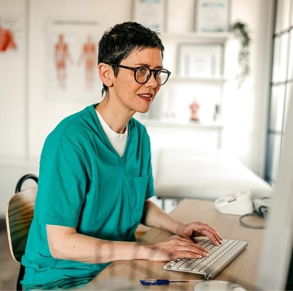 Image of physician at computer working with patients through telepsychiatry