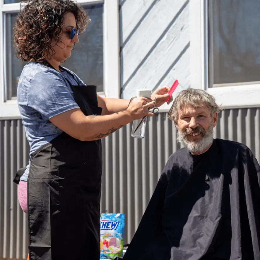 A volunteer hairstylist gives a community member a haircut at a Vituity Cares outreach event.