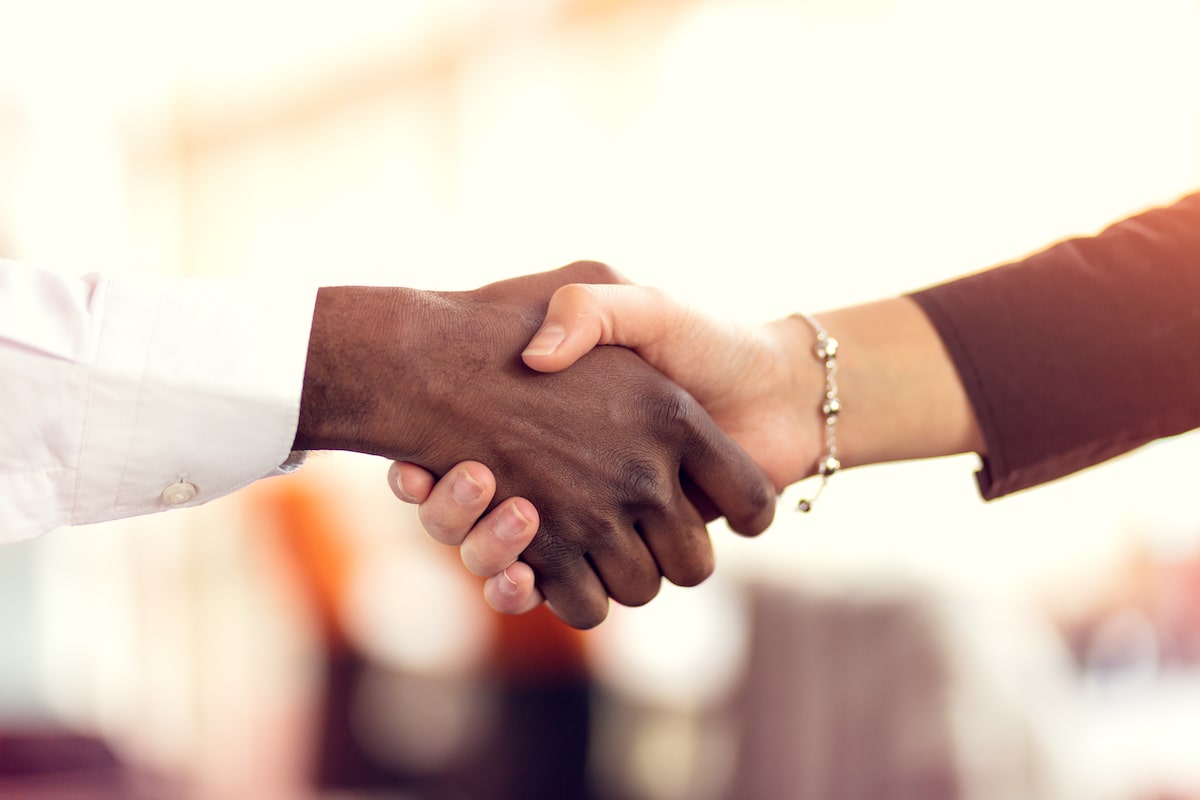 handshake between man and woman executives