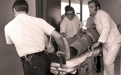 Vituity doctors moving patient with the help of a hospital bed